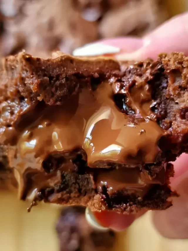 Delicious and gooey Caramel Brownies stacked on a plate, drizzled with caramel sauce.